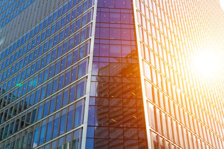 Cityscape featuring modern office exterior from a low angle at sunset.