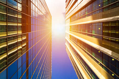 Cityscape featuring modern office exterior from a low angle at sunset.の写真素材