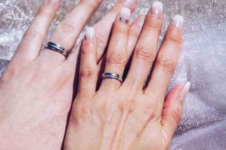 Newly wed couple's hands with wedding ringsの写真素材