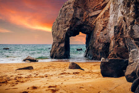 Spectacular natural cliffs and stone arch Arche de Port Blanc and beautiful famous coastline,...
