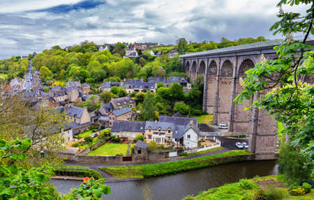 Beautiful view of scenic narrow alley with historic traditional houses and cobbled street in an old town of Dinan with blue sky and clouds. Brittany (Bretagne), Franceの写真素材