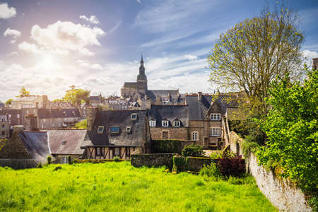 Beautiful view of scenic narrow alley with historic traditional houses and cobbled street in an old town of Dinan with blue sky and clouds. Brittany (Bretagne), Franceのeditorial素材