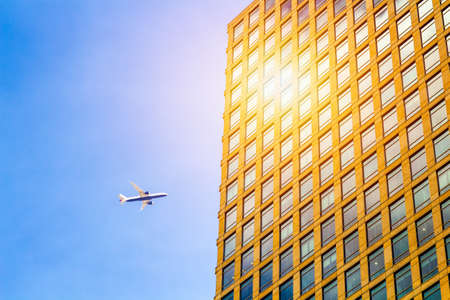 Airplane silhouette with business office towers backgroundの写真素材