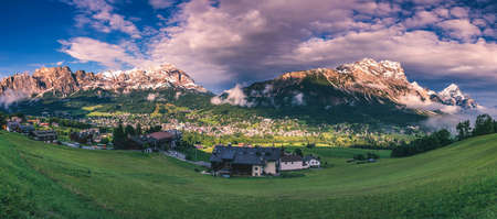 Cortina d'Ampezzo town panoramic view with alpine green landscape and massive Dolomites Alps in the background. Province of Belluno, South Tyrol, Italy.の写真素材