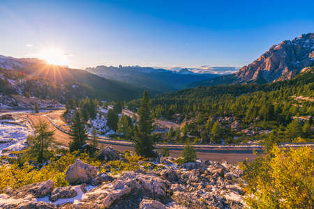 Dolomite Alps in Italy. Beautiful day. The road passes in the coniferous forests at the foot of limestone and dolomite rocks. The concept of active and car tourismの写真素材