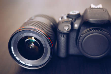 Digital camera or DSLR with camera lens with lense reflections. Photo Camera or Video lens close-up on black background DSLR objectiveの写真素材