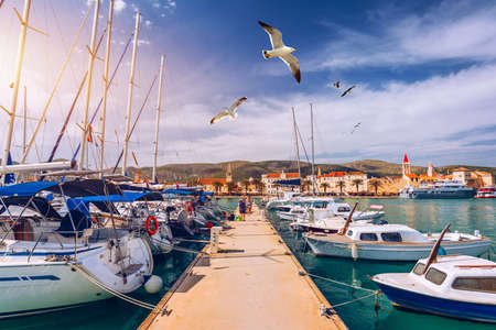 Yachts parking in harbor, Harbor in Trogir, Croatia. Sailboats reflected in water, water transport, beautiful vessel in the harbor, summer vacation, active lifestyle, holiday concept. Trogir, Croatia.の写真素材