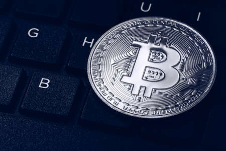 Bitcoin on compuer keyboard in background, symbol of electronic virtual money and mining...