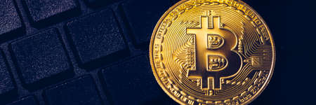 Bitcoin on compuer keyboard in background, symbol of electronic virtual money and mining...