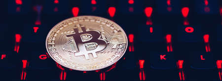 Bitcoin on compuer keyboard in background, symbol of electronic virtual money and mining cryptocurrency concept. Coin crypto currency bitcoin lies on the keyboard. Bitcoin on keyboard.の写真素材