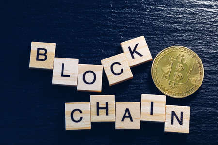 Bitcoins money Virtual currency concept background. Golden bitcoin coin blockchain technology for crypto currency. Digital money currency. Small wooden blocks with block chain text on them.の写真素材
