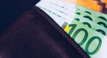 Wallet with Euro banknotes. Cash in the wallet on a black background. Euro money in leather wallet.