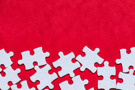 White jigsaw puzzle. White puzzle pieces on color background. Unfinished white jigsaw puzzle pieces on color background.の写真素材