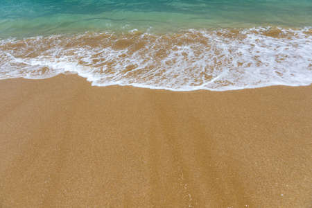 Blue ocean wave on sandy beach. Soft wave of blue ocean on sandy beach. Background. Top view of...