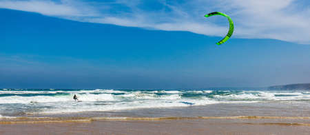 Surfers in Praia da Bordeira beach near Carrapateira, Portugal.