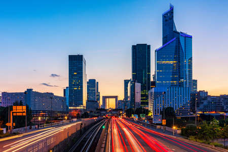 Skyscrapers of La Defense modern business and financial district in Paris. Long exposure of multi-lane road with skyscrapers of business district La Defense, Paris, Franceの写真素材
