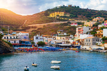 Panorama of Harbour with vessels, boats, beach and lighthouse in Bali at sunrise, Rethymno, Crete, Greece. Famous summer resort in Bali village, near Rethimno, Crete, Greece. の写真素材
