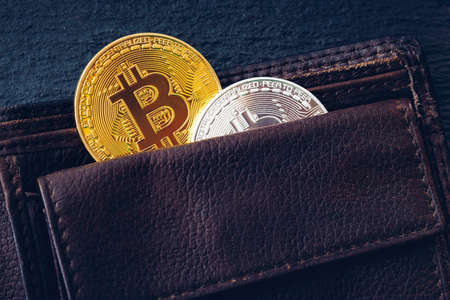 Bitcoin in brown leather wallet. Bitcoin, modern virtual cryptocurrency. Profit from mining crypto...