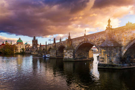 Autumn view to Charles bridge on Vltava river in Prague, Czech Republic. Autumn view to Charles Bridge, Prague old town and Vltava river. Czechia. Scenic autumn view of the Old Town with red foliage.のeditorial素材