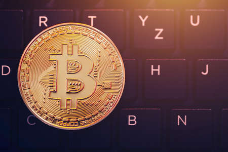 Bitcoin on compuer keyboard in background, symbol of electronic virtual money and mining...