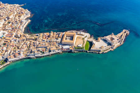 Siracusa, Ortigia Island from the air, Sicily, Italy. Isola di Ortigia, coast of Ortigia island at city of Syracuse, Sicily, Italy. Coastline town Syracuse, Sicily and old Ortigia island. Aerial view.の写真素材