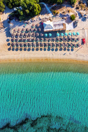 View from above, stunning aerial view of an amazing beach with beach umbrellas and turquoise clear...