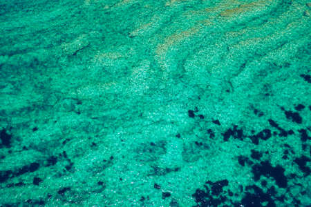 Sea surface aerial view. Background image of the turquoise sea. Deep sea and corals. Aerial drone shot of turquoise water, space for text. Aquamarine background. Sea Aerial view.の写真素材