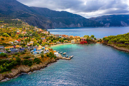 Turquoise colored bay in Mediterranean sea with beautiful colorful houses in Assos village in Kefalonia, Greece. Town of Assos with colorful houses on the mediterranean sea, Greece.の写真素材