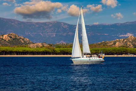 Yacht anchoring in crystal clear turquoise water in front of the tropical island, alternative...