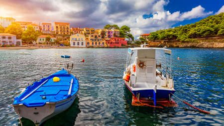Turquoise colored bay in Mediterranean sea with beautiful colorful houses in Assos village in...