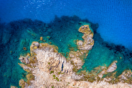 Aerial photo over granite rocky coastline Mediterranean crystal clear blue sea water. Aerial photo...
