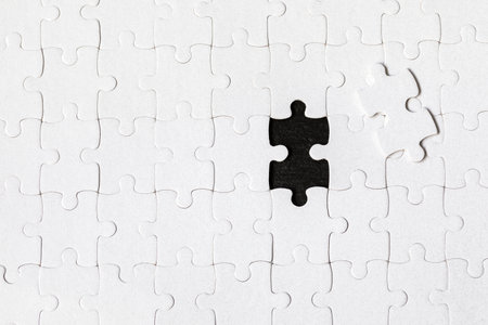 White jigsaw puzzle. White puzzle pieces on color background. Unfinished white jigsaw puzzle pieces on color background.の写真素材
