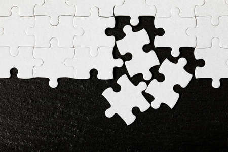 White jigsaw puzzle. White puzzle pieces on color background. Unfinished white jigsaw puzzle pieces on color background.の写真素材