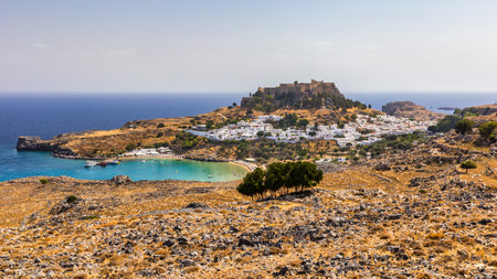 The famous and historical medieval village of Lindos on the Greek island of Rhodes with the Acropolis in the background. Lindos, Rhodes, Greece.の写真素材