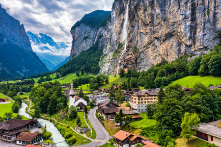 Amazing summer landscape of touristic alpine village Lauterbrunnen with famous church and Staubbach waterfall. Location: Lauterbrunnen village, Berner Oberland, Switzerland, Europe.のeditorial素材