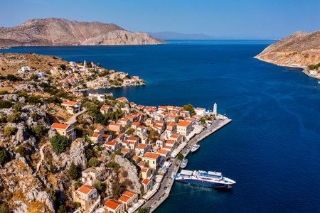 View on Symi (Simi) island harbor port, classical ship yachts, houses on island hills, Aegean Sea...