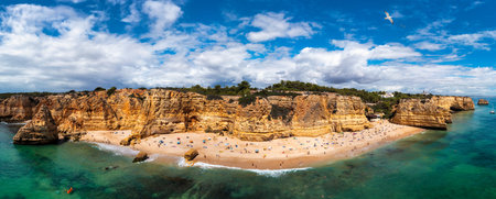 Praia da Marinha, beautiful beach Marinha in Algarve, Portugal. Navy Beach (Praia da Marinha) with flying seagulls over the beach, located on the Atlantic coast in Lagoa Municipality, Algarve.の写真素材