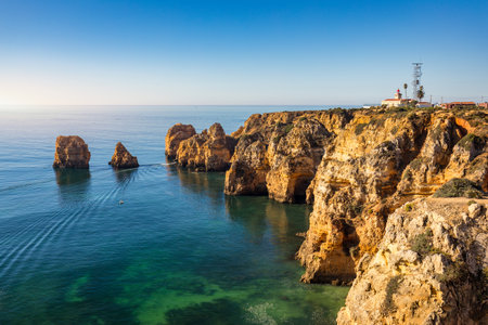 Panoramic view, Ponta da Piedade near Lagos in Algarve, Portugal. Cliff rocks and tourist boat on sea at Ponta da Piedade, Algarve region, Portugal. Ponta da Piedade, Algarve region, Portugal.の写真素材