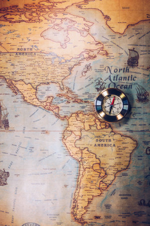 Old vintage retro golden compass on ancient map. Selective focus, shallow depth of field. Concept of world travel, sightseeing and tourism.の写真素材