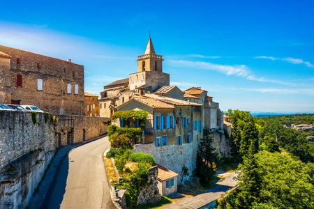 View of Venasque village with old church Notre Dame de Vie to landscape of Luberons, Provence, France. Beautiful Church and houses in the town of Venasque, Provence, France.の写真素材