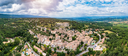 View of the old town of Lacoste, ancient village in France, Vaucluse, Provence-Alpes-Cote d'Azur, Park of Luberon. Lacoste village picturesque countryside of France surrounded by lush green hills.の写真素材