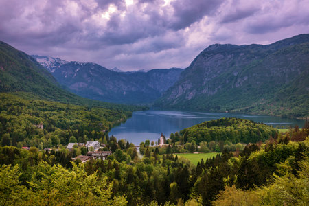 Aerial view of Bohinj lake in Julian Alps. Breathtaking view of the famous Bohinj lake from above. Beautiful view of the Triglav national park and the church of St John the Baptist. Slovenia, Europeの写真素材