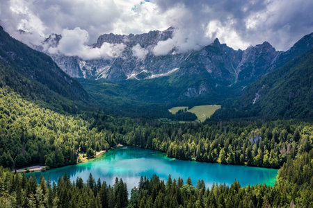 Picturesque lake Lago Fusine in Italy. Fusine lake with Mangart peak on background. Popular travel...