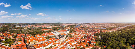 Panoramic view of Prague featuring historic buildings and vibrant rooftops on a sunny day in summer. View of Prague, Czech Republic, showcasing the city's iconic architecture and red-tiled roofs.の写真素材