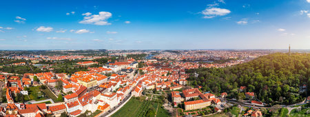 Panoramic view of Prague featuring historic buildings and vibrant rooftops on a sunny day in summer. View of Prague, Czech Republic, showcasing the city's iconic architecture and red-tiled roofs.の写真素材