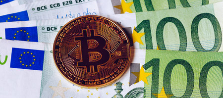 Golden bitcoin over Euro money. Bitcoin cryptocurrency. Crypto currency concept. Bitcoin with euro...