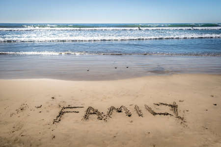 The word family written in the sand at beachの写真素材