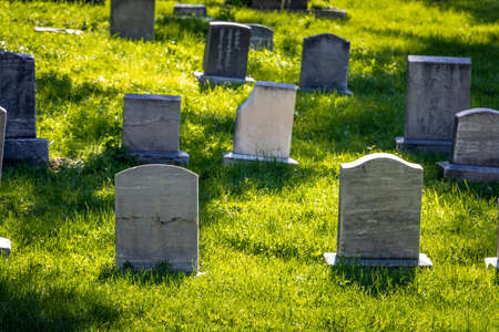 Group of old headstones of graves on the side of a hill