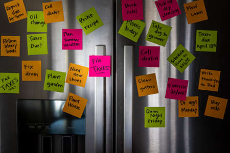 Refrigerator door with colorful memo notes reminding to file taxesの写真素材