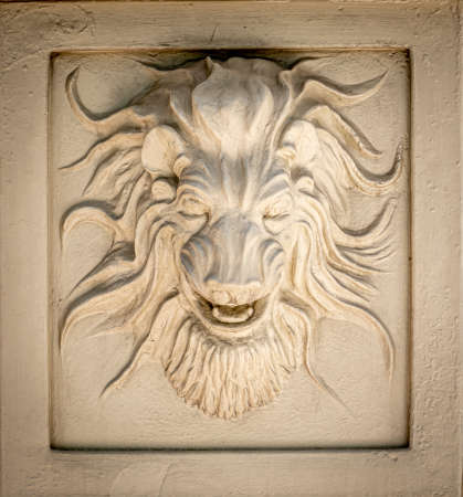 Close up of tan colored lion head exterior wall decoration on building wallの写真素材